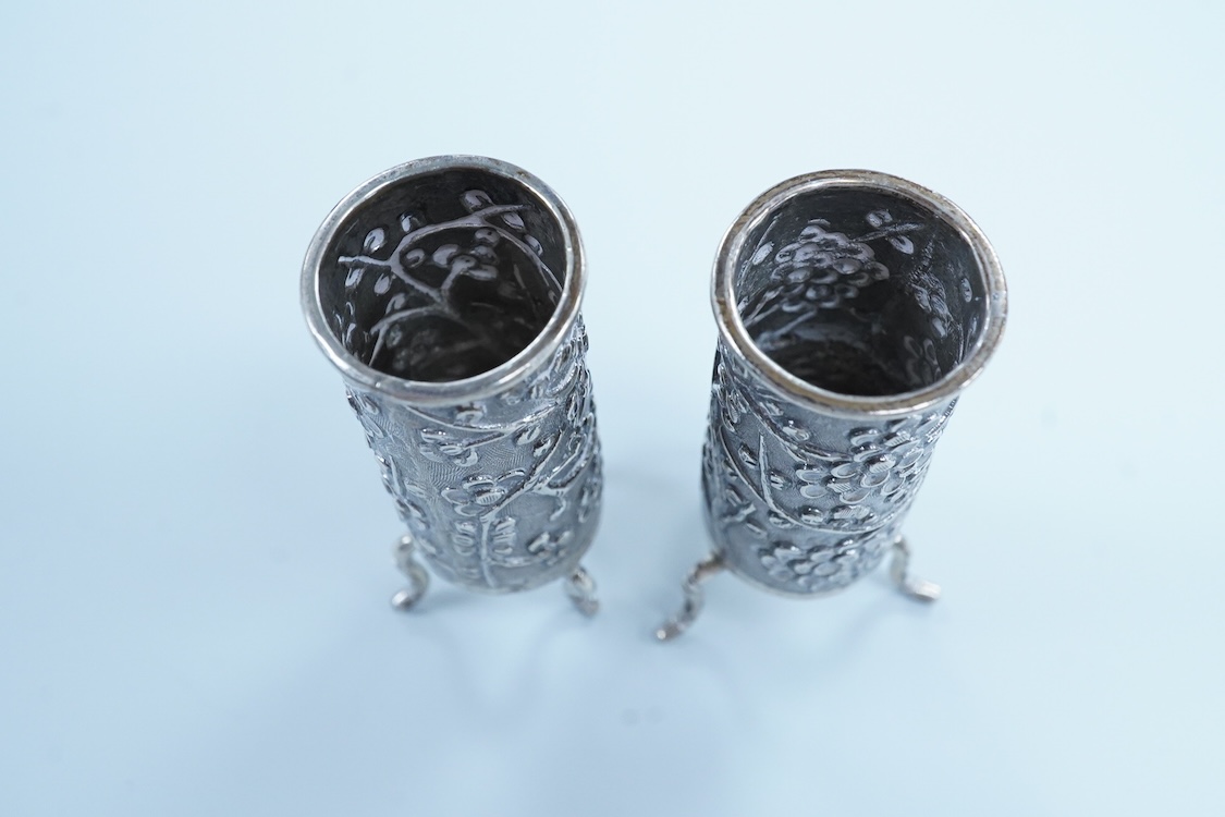 A pair of late 19th/early 20th century Chinese Export white metal cylindrical toothpick holders, by Wang Hing, Hong Kong, stamped 'WH90', on tripod feet, height 6cm.